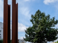 Presentation of a watch tower.  The Berlin Wall Foundation uses an abstract representation here to show the watchtower. It is designed to give an impression of the size of the watchtower that was dismantled on Strelitzer Strasse in 1990 and also to convey a sense of the total surveillance of the border strip. The position of the steel construction is based on the tower that originally stood at this historic site. Four 11.8 meter high square-angled columns made of weathering steel are positioned into a square and set into a concrete foundation. : 2016, Berliini, Berlin, Fujifilm, Germany, Saksa, digital image, historia, history, kaupunki, kesäloma, matka, summer holiday, town, travel