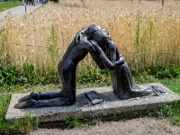 Reconciliation  St. Michael's Cathedral in Coventry, England, presented this statue to the Chapel of Reconciliation in Berlin on November 9, 1999. Entitled "Reconciliation," the statue depicts a young man and woman kneeling to embrace across a barrier. The German Luftwaffe bombed St. Michael's Cathedral in November 1940, killing 568 people; the parish, instead of demanding retribution after the war, accepted the German offer to help rebuild the church. Replicas of the statue are also found in the peace garden of Hiroshima and in Belfast. : 2016, Berliini, Berlin, Fujifilm, Germany, Saksa, digital image, historia, history, kaupunki, kesäloma, matka, summer holiday, town, travel