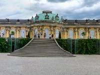 Sanssouci Palace  Sanssouci is the former summer palace of Frederick the Great, King of Prussia, in Potsdam, near Berlin. It is often counted among the German rivals of Versailles. While Sanssouci is in the more intimate Rococo style and is far smaller than its French Baroque counterpart, it too is notable for the numerous temples and follies in the park. The palace was designed/built by Georg Wenzeslaus von Knobelsdorff between 1745 and 1747 to fulfill King Frederick's need for a private residence where he could relax away from the pomp and ceremony of the Berlin court. The palace's name emphasises this; it is a French phrase (sans souci), which translates as "without concerns", meaning "without worries" or "carefree", symbolising that the palace was a place for relaxation rather than a seat of power. Sanssouci is little more than a large, single-story villa—more like the Château de Marly than Versailles. Containing just ten principal rooms, it was built on the brow of a terraced hill at the centre of the park. The influence of King Frederick's personal taste in the design and decoration of the palace was so great that its style is characterised as "Frederician Rococo", and his feelings for the palace were so strong that he conceived it as "a place that would die with him". Because of a disagreement about the site of the palace in the park, Knobelsdorff was fired in 1746. Jan Bouman, a Dutch architect, finished the project : 2016, Fujifilm, Potsdam, digital image, historia, history, kaupunki, kesäloma, matka, summer holiday, town, travel