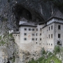 Predjama Castle. The castle was first mentioned in the year 1274 with the German name Luegg, when the Patriarch of Aquileia built the castle in Gothic style. The castle was built under a natural rocky arch high in the stone wall to make access to it difficult. It was later acquired and expanded by the Luegg noble family, also known as the Knights of Adelsberg (the German name of Postojna).