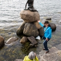 The Little Mermaid sits on a rock in the harbour off Langelinie promenade. It has a height of 1.25 metres and weighs 175 kilograms.<br />The statue was commissioned in 1909 by Carl Jacobsen, son of the founder of Carlsberg, who had been fascinated by a ballet about the fairytale in Copenhagen's Royal Theatre and asked the prima ballerina, Ellen Price, to model for the statue. The sculptor Edvard Eriksen created the bronze statue, which was unveiled on 23 August 1913. The statue's head was modelled after Price, but as the ballerina did not agree to model in the nude, the sculptor's wife, Eline Eriksen, was used for the body.