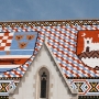 The tiles on the left side depict the medieval coat of arms of Croatia, Dalmatia and Slavonia, while the emblem of Zagreb is on the right side.