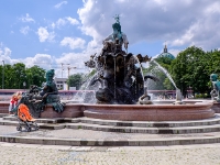 Neptunbrunnen  The Neptune Fountain in Berlin was built in 1891 and was designed by Reinhold Begas. The Roman god Neptune is in the center. The four women around him represent the four main rivers of Prussia at the time the fountain was constructed: the Elbe (with the allegorical figure holding fruits and ears of corn), Rhine (fishnet and grapes), Vistula (wooden blocks, symbols of forestry), and Oder (goats and animal skins). The Vistula is now entirely in Poland, while the Oder forms the border between Germany and Poland : 2016, Berliini, Berlin, Fujifilm, Germany, Saksa, digital image, historia, history, kaupunki, kesäloma, matka, summer holiday, town, travel