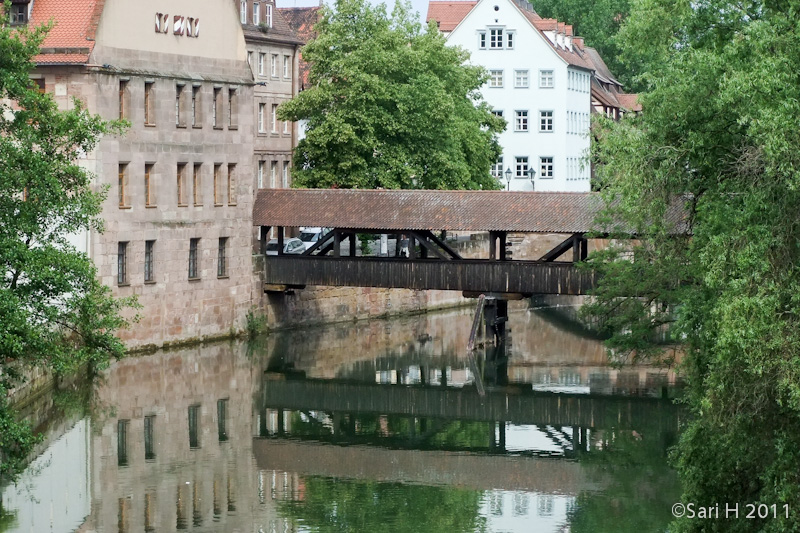 nurmberg-45.jpg - Henkersteg (Hangman's Bridge) was constructed in 1457 as a wooden bridge. Between the 16th and the 19th century, the Nuremberg hangman lived in the tower and the roofed walk above the river Pegnitz. After the flood of 1595, three arches of the town wall bridging the southern arm of the river Pegnitz were demolished and replaced by the wooden Hangman's Bridge with its tiled roof (reconstructed in 1954).