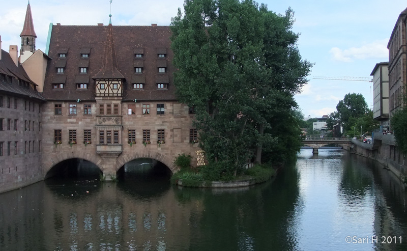 nurmberg-5.jpg - Heilig-Geist-Spital (The Hospital of the Holy Spirit), was built between 1332 and 1339 and was a foundation endowed by the rich Patrician Konrad Groß ("Imperial Mayor") for old and needy people, then considered the largest foundation donated by any individual in the Empire before 1500. After 1500, following designs by Hans Beheim the Elder, it was expanded over the river Pegnitz with the "Sude" and the "Bau". Still standing today: the houses for the preacher in the "Sude" and for the administrator, along the southern arm of the river Pegnitz, as well as the northern wall of the former Hospice Church with its polygonal roof turret (Hans-Sachs-Platz). The chapel which was not reconstructed was the place where the Crown Jewels of the Empire were stored between 1424 and 1796.